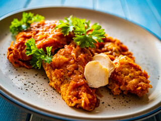 Fish dish - fried fish fillet in vegetable sauce on wooden table
