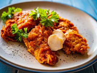 Fish dish - fried fish fillet in vegetable sauce on wooden table
