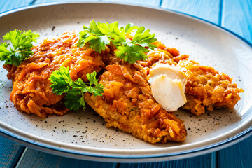 Fish dish - fried fish fillet in vegetable sauce on wooden table
