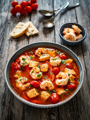 Fish soup with prawns on wooden table