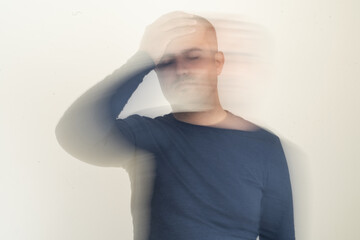 Close up photo of man with vertigo ilness. Motion blur effect intentionally applied. Dizziness and tension and medicine side effect concept. - obrazy, fototapety, plakaty