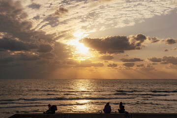 Fototapeta premium 沖縄 北谷 宮城海岸で夕日を見る人々