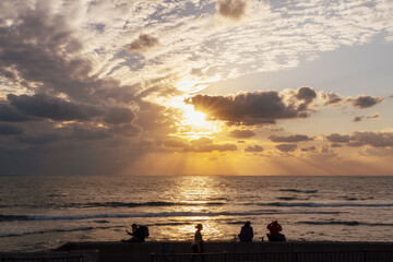沖縄　北谷　宮城海岸で夕日を見る人々