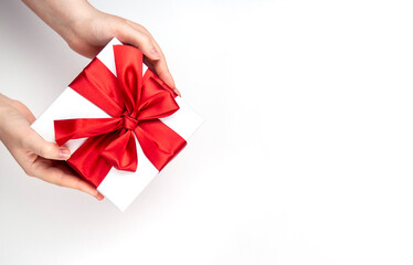 A box with a red bow in its hands. The concept of congratulations, a gift.