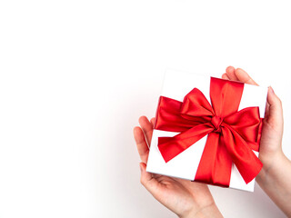 A box with a red bow in its hands. The concept of congratulations, a gift.
