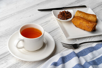 Russian pancakes with filling lying on a plate on table