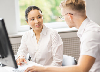 Fototapeta premium Team of professional support staff working in the office. Colleagues in the workplace solve customer problems. Call center and customer support concept.