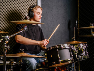 Fototapeta na wymiar Young man playing drums in a recording studio