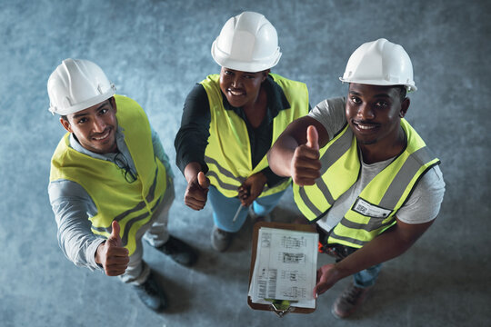 Youre good to go. High angle shot of a group of contractors standing in the warehouse together and making a thumbs up gesture.