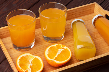 Glass of fresh orange juice with fresh fruits on wooden table