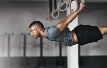 Pure power. Cropped shot of a young man working out on the gymnastics rings.