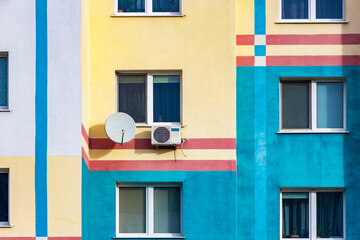 An air conditioning system installed outside on the wall of a multistory building. satellite dish. Ventilation and air conditioning of housing. TV signal.