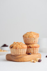 Muffins in a wooden plate on a white table