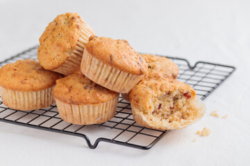 Vanilla fresh baked muffins on a white table with nuts and berries