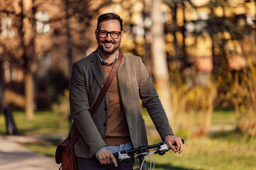 Fototapeta na wymiar Portrait of a smiling man, holding a bicycle handlebar, walking.