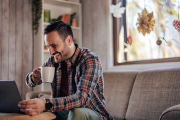 The smiling man, drinking his first-morning coffee, having an ea