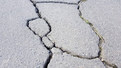 Obraz premium Old road surface made of asphalt with cracks in sunny day