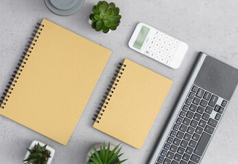 Flat lay on concrete background. Office desk working space with coffee cup, succulents and notebook.