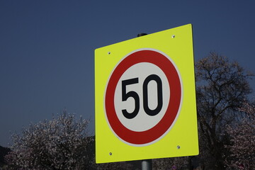 German traffic sign 'Speed limit 50 km per hour' on neon yellow square, concept: limitation,...