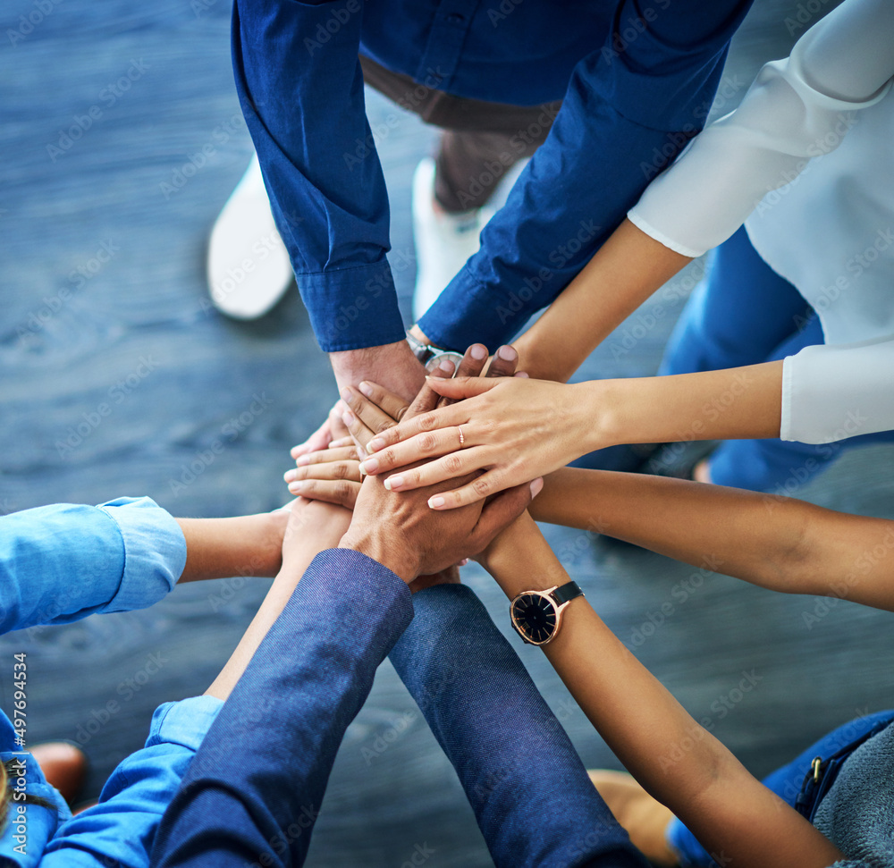 Wall mural Lets awaken the team spirit. High angle shot of a group unrecognizable businesspeople joining their hands together in unity.