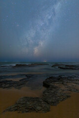 Milky way galaxy over the rocky coastline.