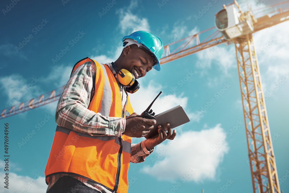 Poster new age tech for new age construction. shot of a young man using a digital tablet while working at a