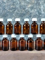 Pattern of bottles of medicine on wooden table and black concrete background with copy space