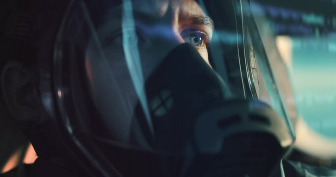 Close up shot of determined military armed forces soldier or pilot wearing protective oxygen visor mask inside cockpit of fighter jet airplane during aviation warfare or flight training routine.