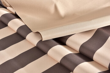 Dense beige fabric with a wide brown stripe. Thick fabric for awnings