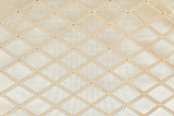 Rhombus pattern on a beige background. Polyester fabric, jacquard close-up