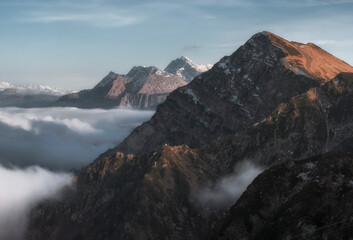 alpine landscape with peaks covered by snow and clouds