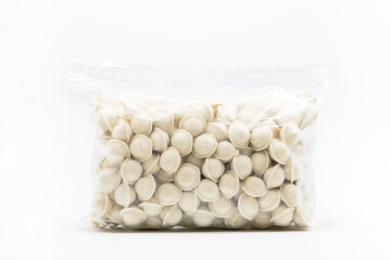 Fototapeta na wymiar Frozen uncooked dumplings in plastic bag on white. Semi-finished product pelmeni.