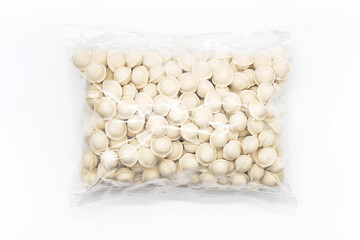 Frozen uncooked dumplings in plastic bag on white. Semi-finished product pelmeni.