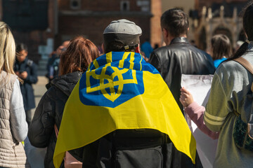 Flag of Ukraine on the shoulders of an activist in a group of protesters on the street of a...