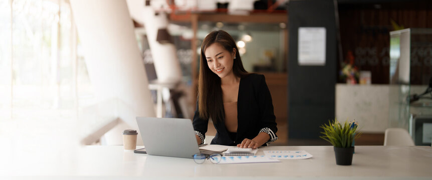 Portrait asian business woman working on laptop computer and calculator for financial. business accounting concept