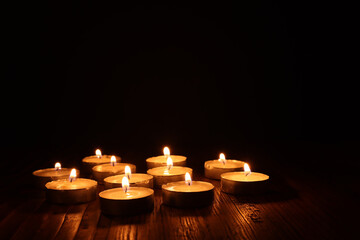 Burning candle over black background