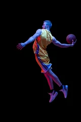 Fotobehang Portrait of sportive man, professional basketball player playing basketball isolated on dark background in neon light. Achievements, sport career, motion concepts. © master1305
