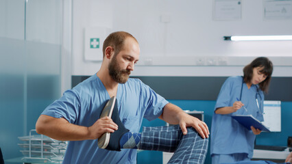 Health therapist cracking legs bones and stretching muscles, treating senior man with mechanical disorders to increase mobility. Male doctor using physical exercise to recover from injury.