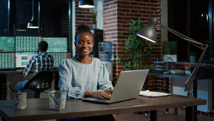 Portrait of sales consultant using trade market statistics on laptop to plan financial exchange...