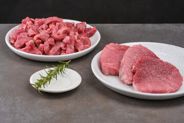 Raw minced meat. Fresh cut of beef in white plate with salt, pepper, garlic, rosemary. Raw steak beef meat fillet ready to cook. Selective focus	