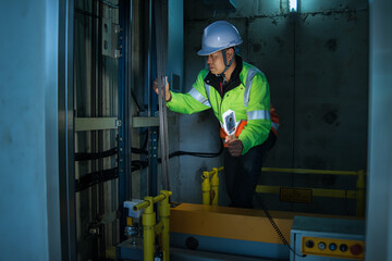 People in elevator shaft. service engineer checking inspector part of  elevator. worker check in...