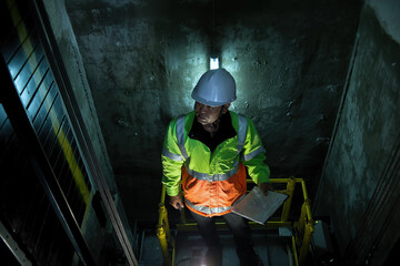 People in elevator shaft. service engineer checking inspector part of  elevator. worker check in...