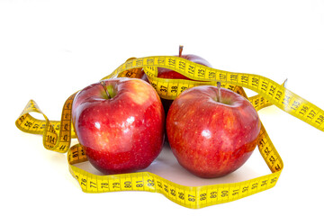 close up of several red apples isolated on a white background with a measuring tape