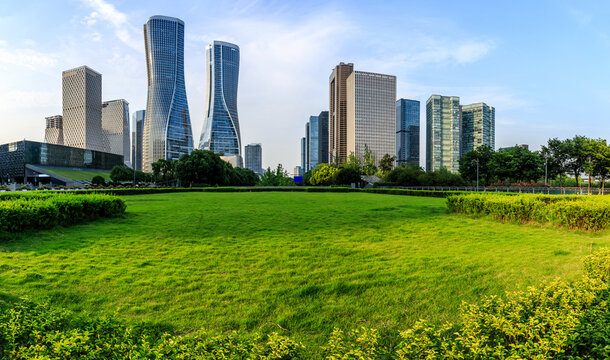 City Skyline And Modern Commercial Buildings With Green Grass In Hangzhou, China.