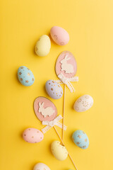 Easter colorful eggs on a yellow backgroun. Top view. Easter card. Vertical photo