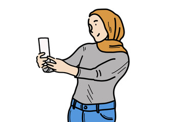 携帯電話を掲げているイスラム系の女の人。