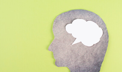 Silhouette of a face, speech bubble in white color, copy space for text, communication, having an opinion, free speech, people talking, green background