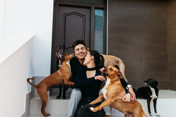 Couple having fun with their playful dogs at home
