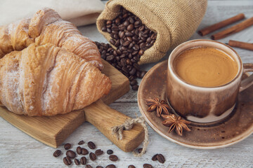 Cup of coffee and croissants on the table. Fragrant stimulating drink. Fresh bakery. Breakfast, snack.
