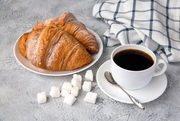 Cup of coffee and croissants on the table. Fragrant stimulating drink. Fresh bakery. Breakfast, snack.
